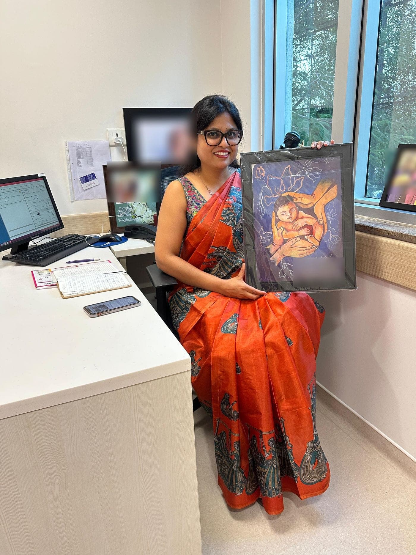 Dr. Nikita in her consulting room with a painting gifted by a family