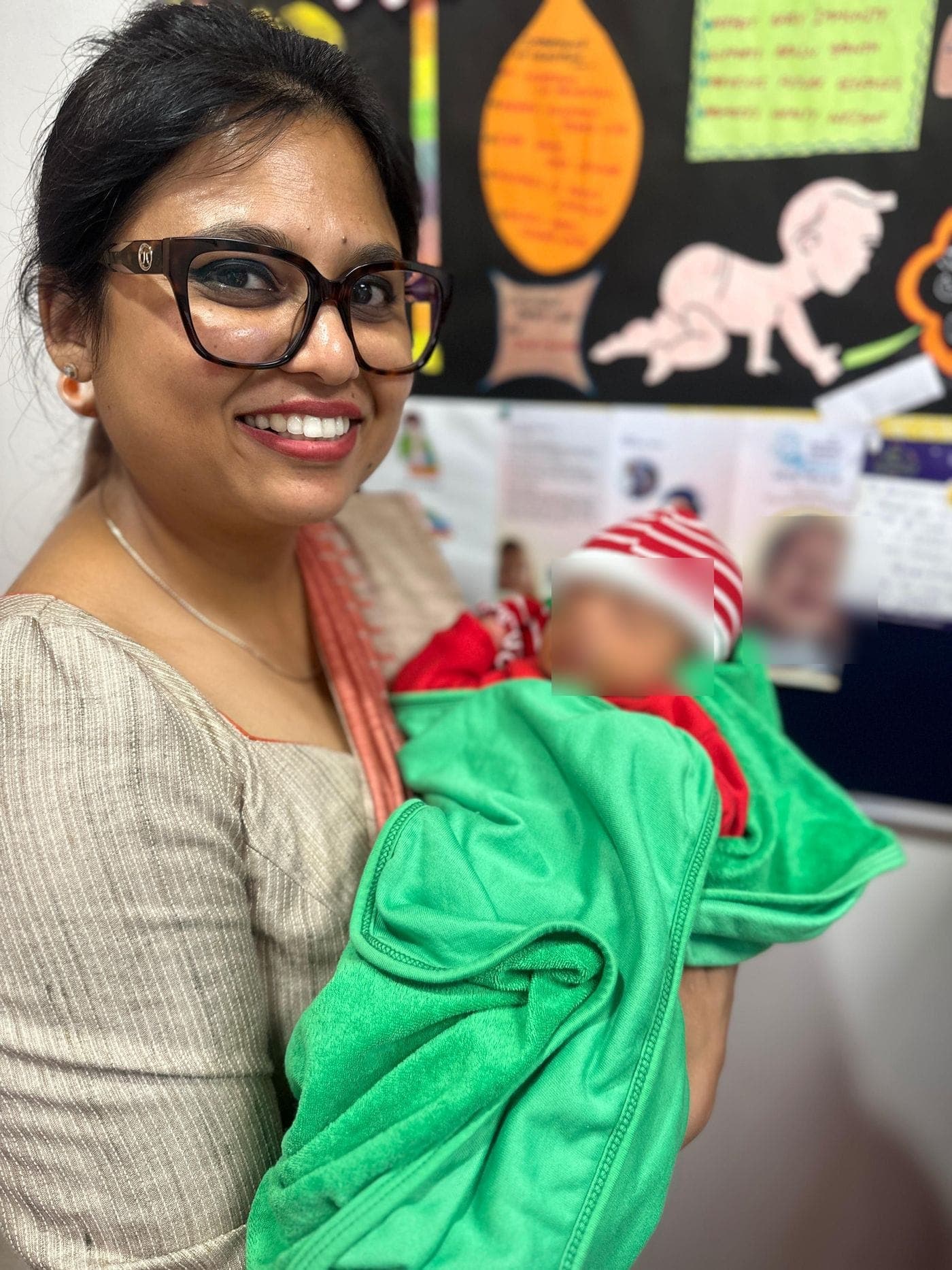 Dr. Nikita cradling a newborn wrapped in a blanket